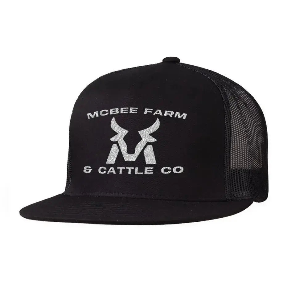 The McBee Farms Flat Bill Hat by McBee Farm & Cattle Co is a black trucker hat featuring a mesh back, adjustable closure, and high-profile design. It showcases a white logo with a stylized bull head and the text MCBEE FARM & CATTLE CO, blending classic style with modern comfort.