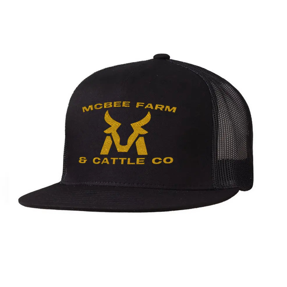 The McBee Farms Flat Bill Hat by McBee Farm & Cattle Co is a black 5-panel trucker hat with a mesh back, adorned with yellow MCBEE FARM & CATTLE CO text and a bull head logo on the front. It features an adjustable closure for the perfect fit.
